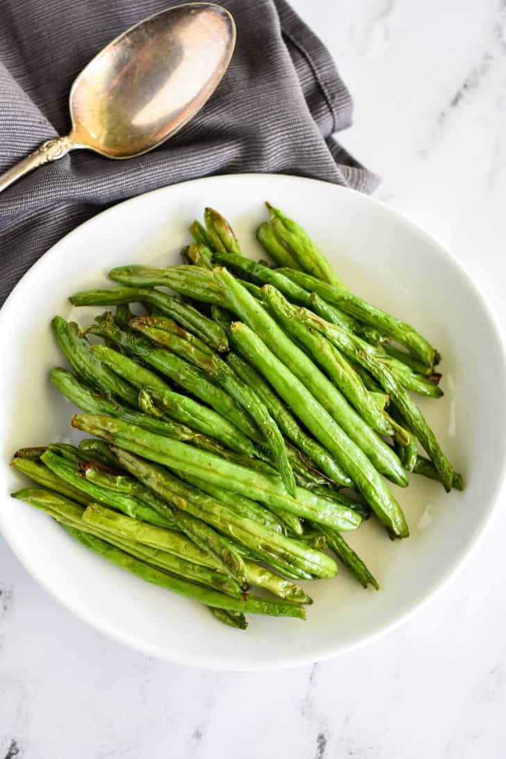 overhead of air fryer green beans on a white plate.