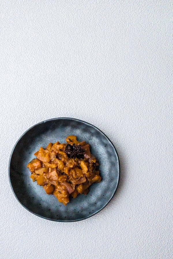 overhead of peach chutney dressing on a dark plate.