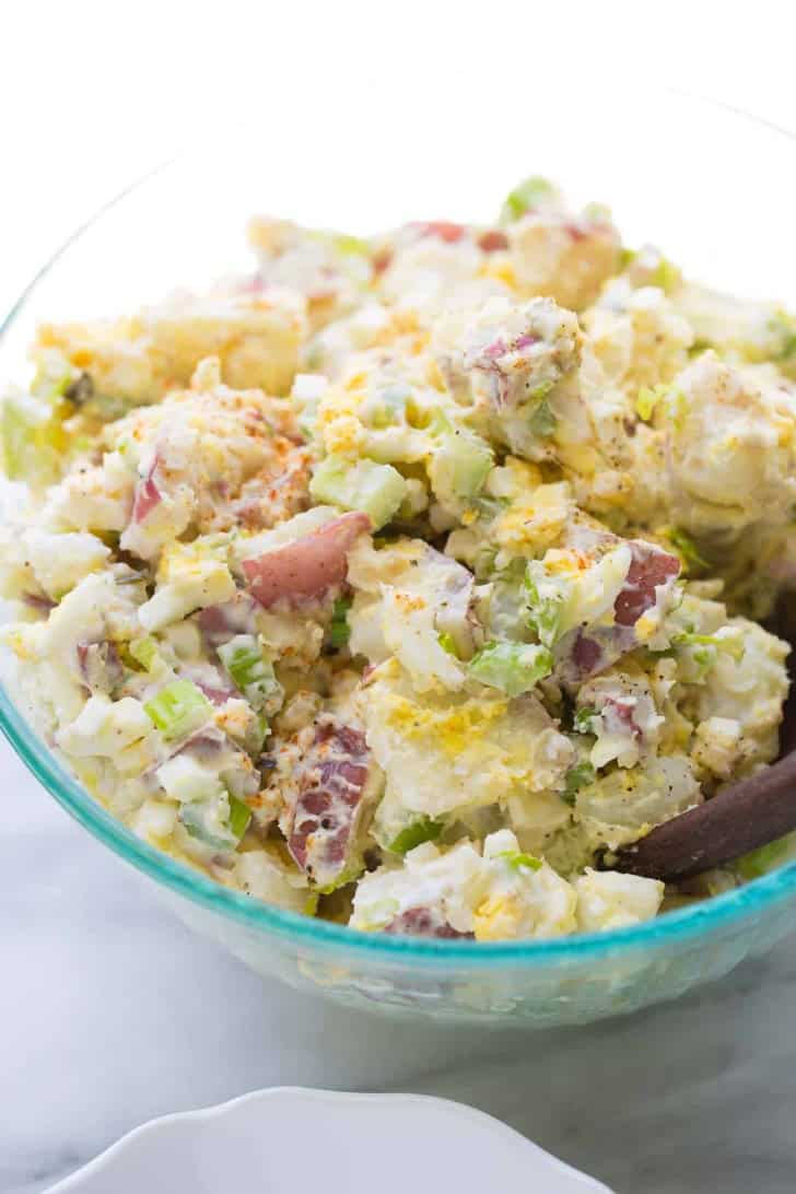 slight overhead of potato salad in a glass bowl.