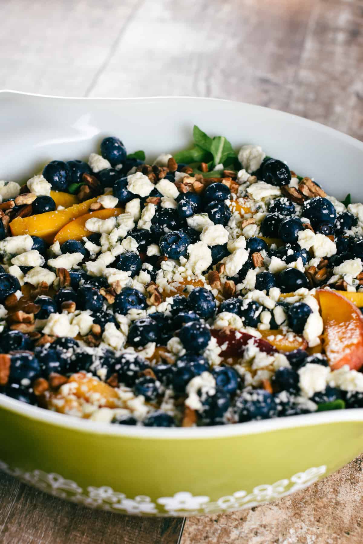 blueberry and peach arugula salad in a large serving bowl.