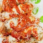 pin of close-up overhead of skillet chicken parmesan on a plate with title text overlay.