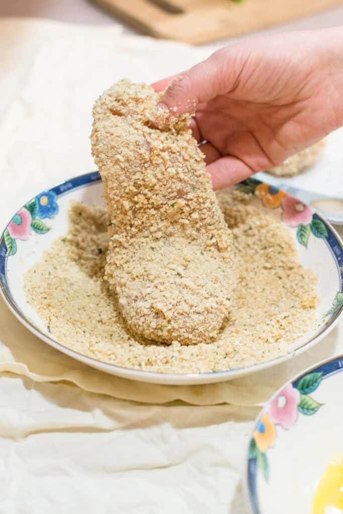 piece of chicken after coating with breadcrumbs.