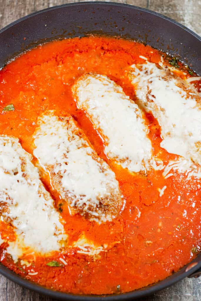 overhead shot of chicken parmesan in the skillet after the cheese has melted.