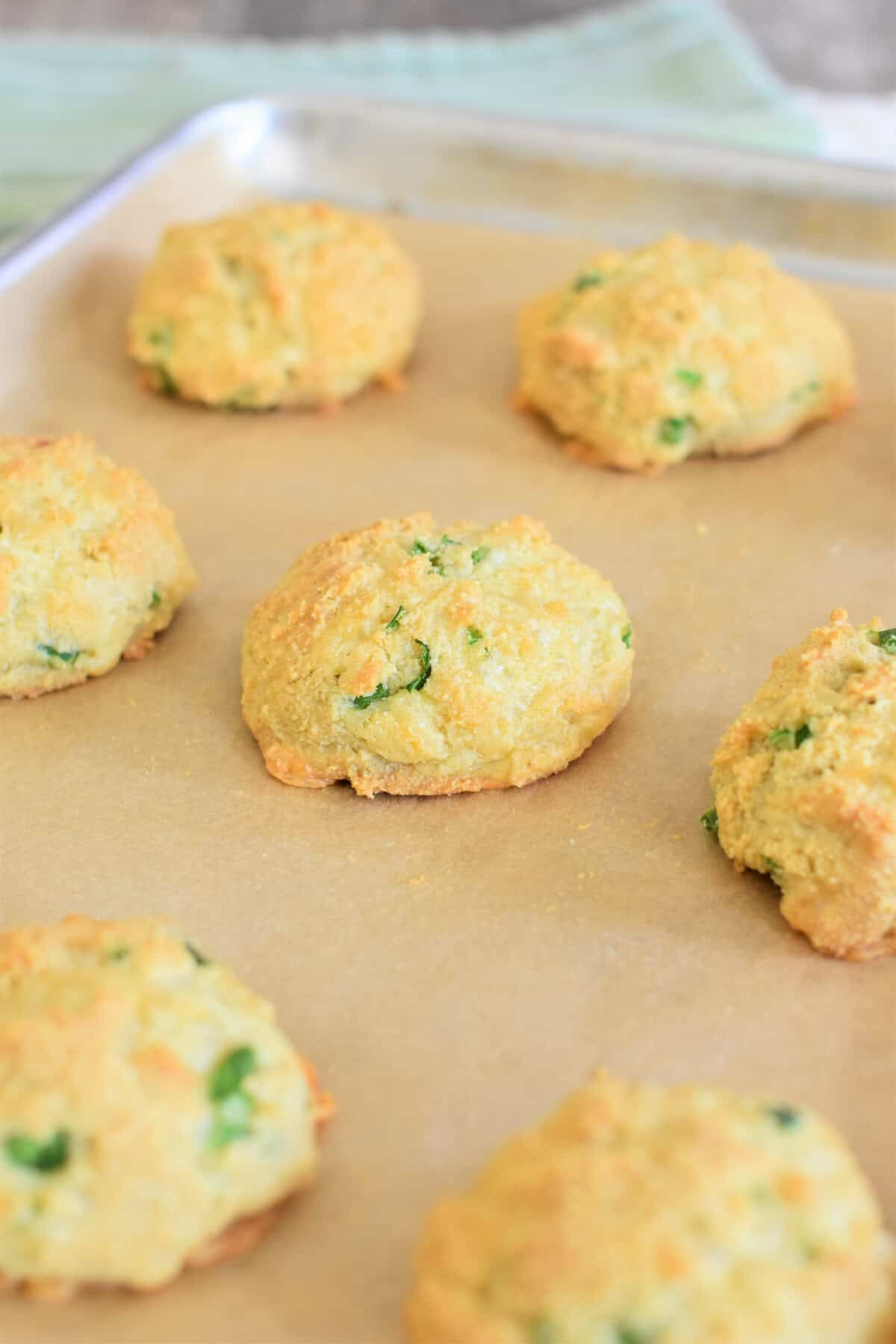 Baked biscuits on a parchment-lined sheet pan.