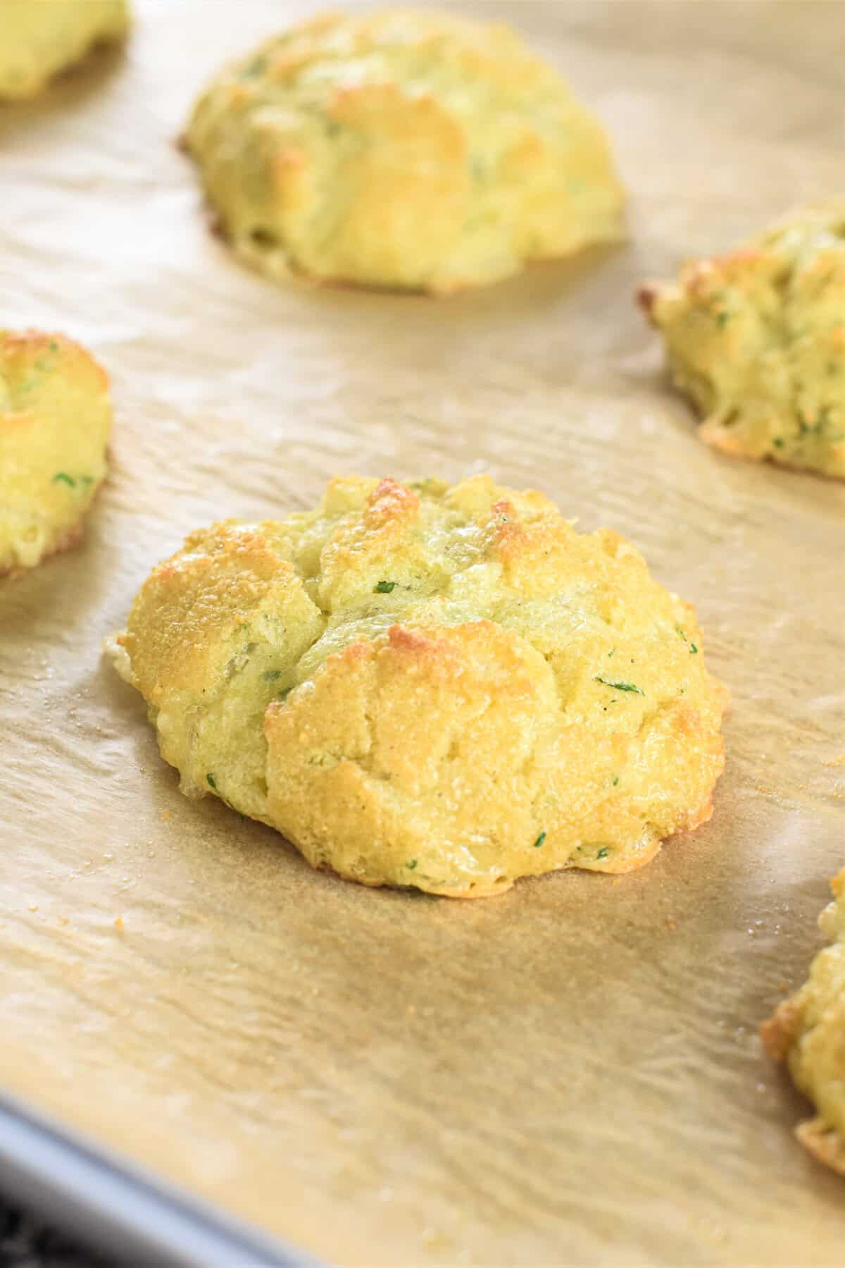 Close-up of low-carb biscuit on a baking sheet with more in the background.