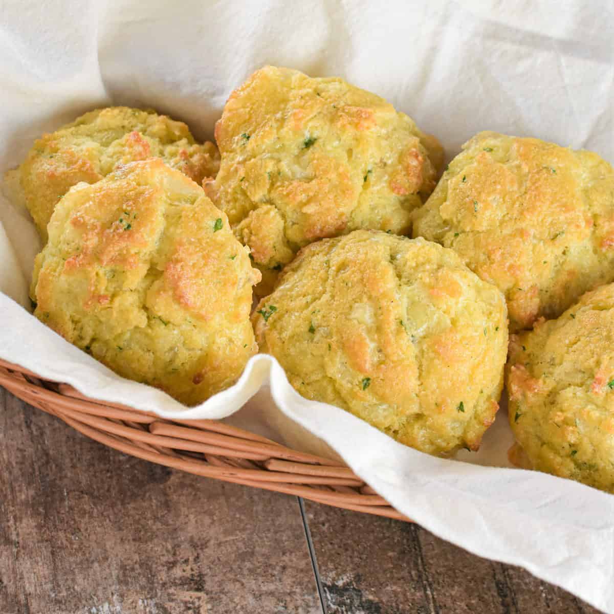 Several low-carb biscuits on a kitchen napkin in a wicker basket.