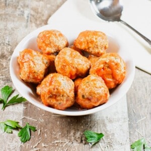 easy baked turkey meatballs with sauce in a white bowl.