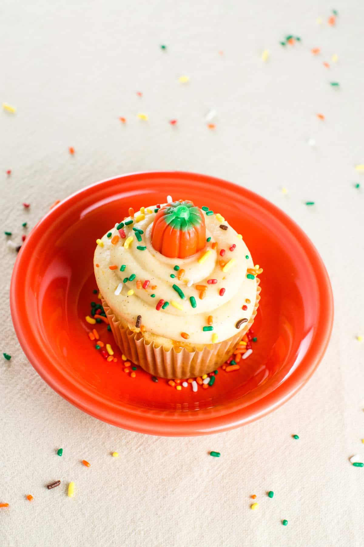 A fall-decorated cupcake in an orange dish.