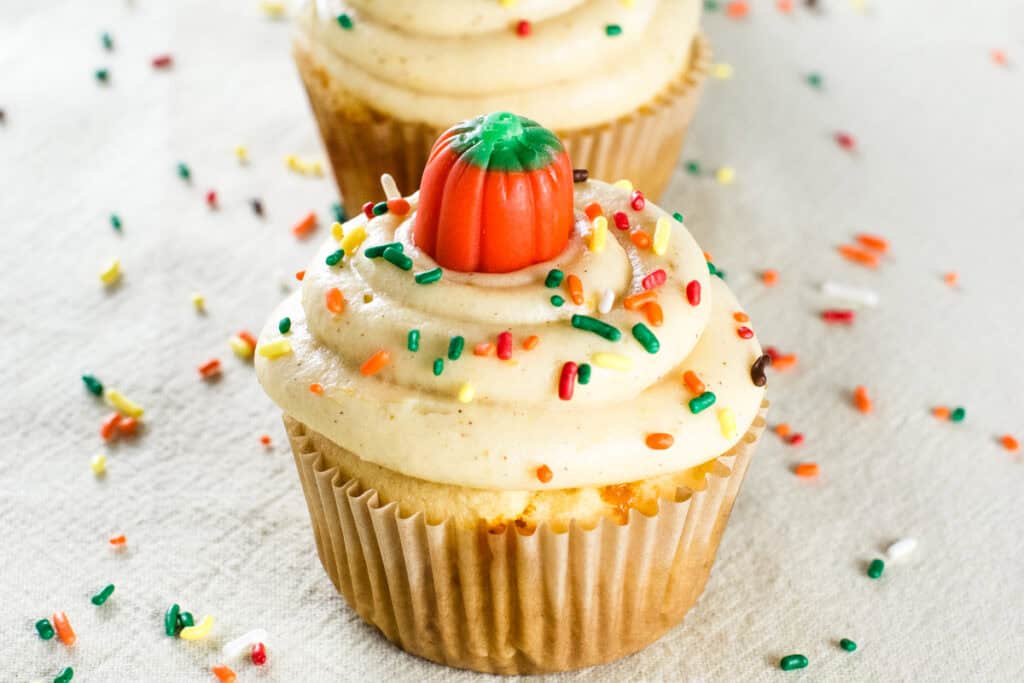 Close-up of a fall-decorated cupcake with sprinkles around.