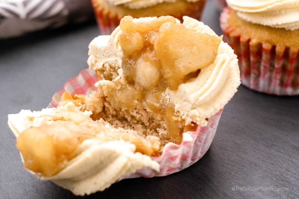 An open apple pie cupcake on a gray surface.