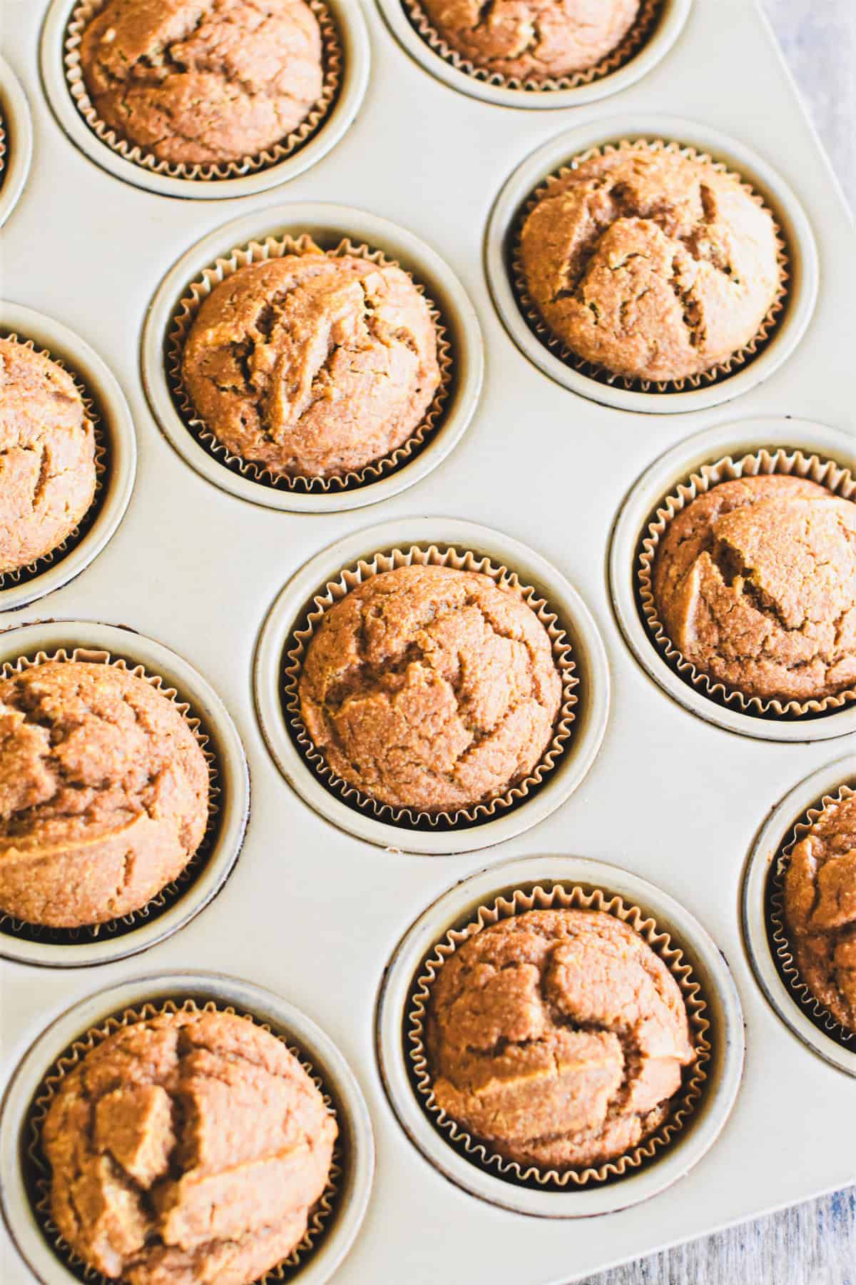 Pumpkin oat flour muffins in a muffin tin after baking.