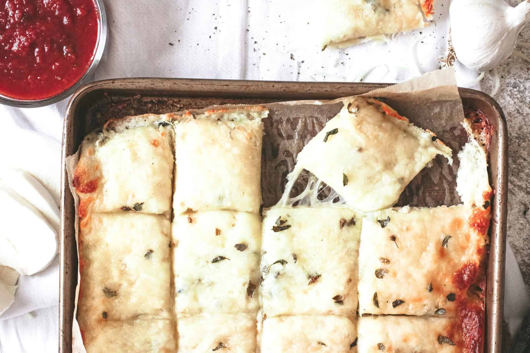 Cheesy garlic bread on a baking sheet.