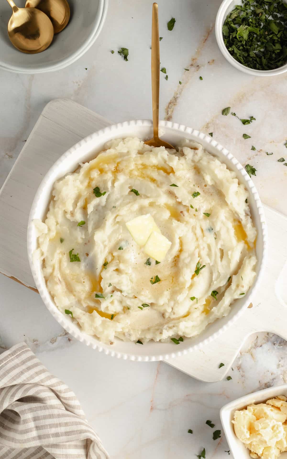 Dairy-free mashed potatoes in a white bowl with a spoon in it.