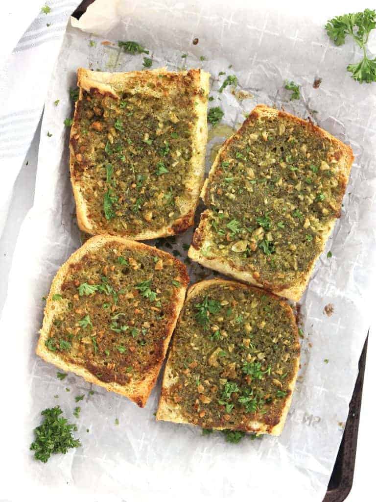 Pesto garlic bread on a white serving platter.