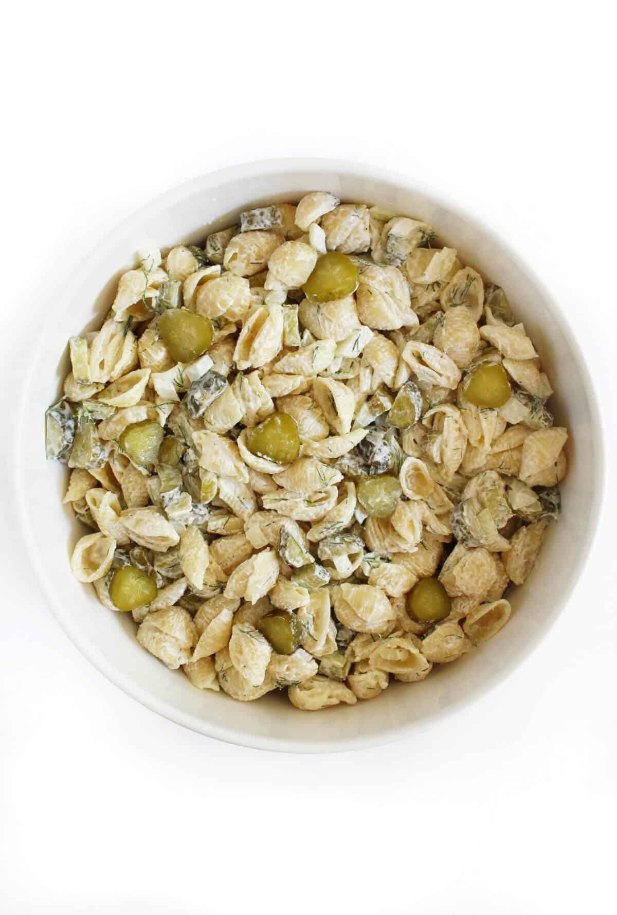 Dill pickle pasta salad in a white serving bowl.