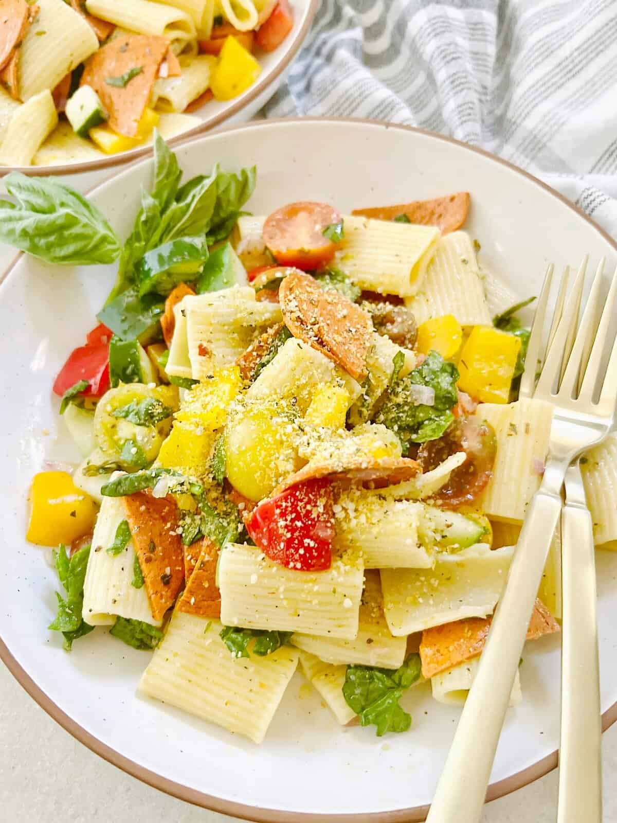 Vegan Italian pasta salad on a white plate with a fork.