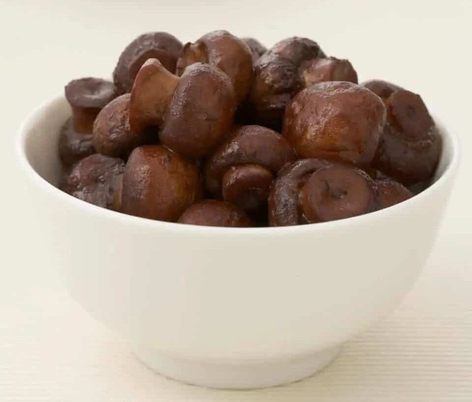 Marinated mushrooms in a white bowl.