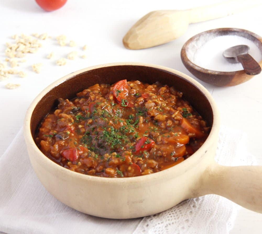 A serving of vegan soy stew in an off-white crock.