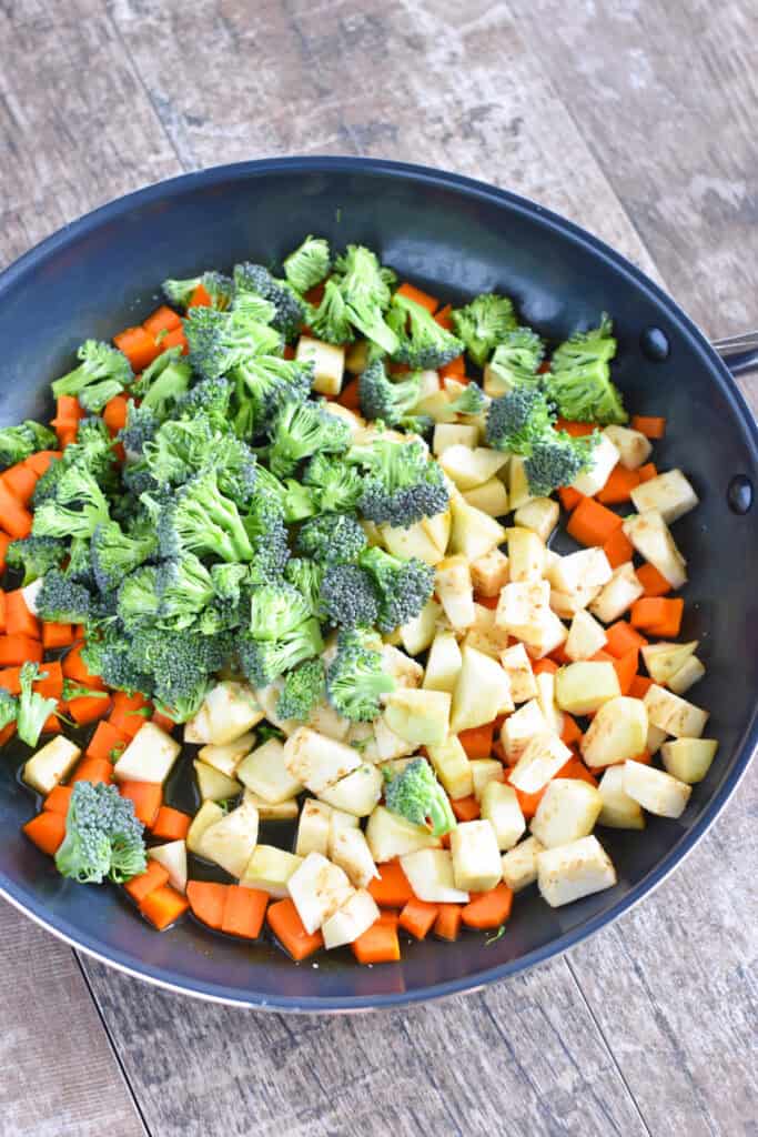 Diced eggplant and chopped broccoli added to carrots in a nonstick skillet.